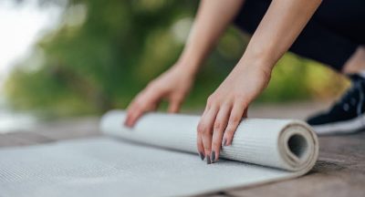 Closeup of yoga mat, being rolled after a complete workout.